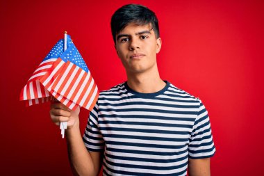 Amerika Birleşik Devletleri bayraklarını tutan genç, yakışıklı, vatansever bir adam. Bağımsızlık Günü 'nü kutluyor.