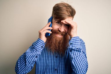 Kızıl saçlı, sakallı İrlandalı bir adam, kapalı bir arka planda telefonla konuşuyor. Elleri başının üstünde, utanç ve şaşkınlık dolu, sinirli ve hayal kırıklığına uğramış bir halde. Hata için korku ve üzüntü.