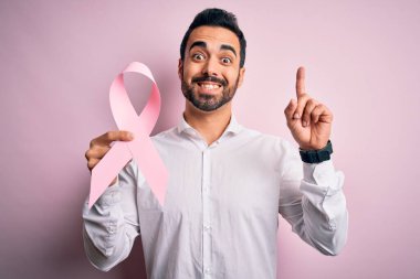 Sakallı, pembe kanser kurdelesi takan genç yakışıklı bir adam bir fikre ya da soru işaretine şaşırdı.