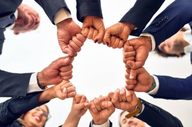 Group of business workers smiling happy and confident. Standing on a circle with smile on face doing symbol with fists together at the office.