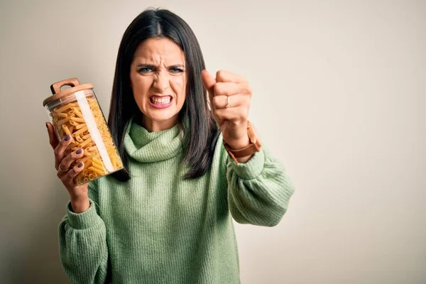 Mujer Morena Joven Sosteniendo Macarrones Italianos Secos Sobre Fondo Aislado —  Fotos de Stock