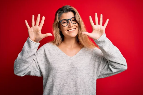 Mladá Krásná Blondýna Žena Nosí Svetr Brýle Izolovaném Červeném Pozadí — Stock fotografie