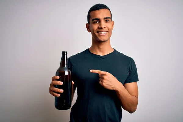 Νεαρός Όμορφος Αφροαμερικάνος Πίνει Μπύρα Λευκό Φόντο Πολύ Χαρούμενος Δείχνοντας — Φωτογραφία Αρχείου