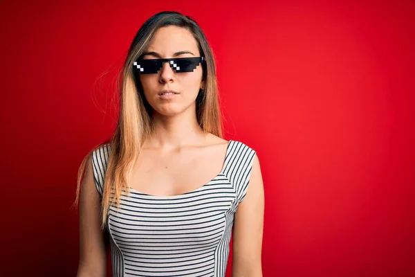 Młoda Piękna Brunetka Ubrana Śmieszne Okulary Przeciwsłoneczne Czerwonym Tle Poważnym — Zdjęcie stockowe