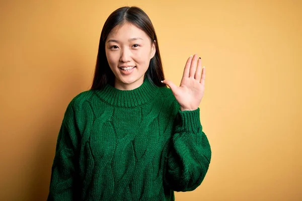 초록색 스웨터를 아리따운 아시아 배경을 드러내며 자신감 미소를 가운데 손가락 — 스톡 사진