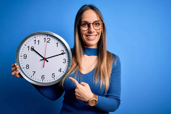 Young Blonde Woman Blue Eyes Holding Big Minute Clock Isolated — Stock Photo, Image