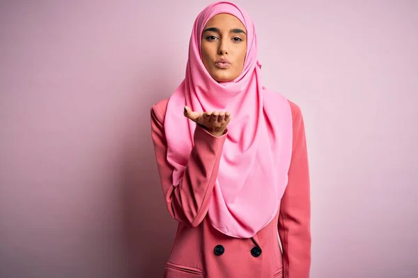 年轻美丽的黑发女商人 头戴粉色穆斯林头巾 身穿商务夹克 看着相机 与空气中的手吹一个吻是可爱和性感的 爱的表达 — 图库照片