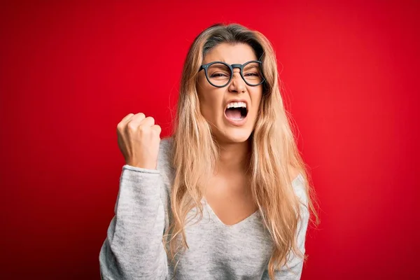 Jovem Mulher Loira Bonita Vestindo Suéter Óculos Sobre Fundo Vermelho — Fotografia de Stock