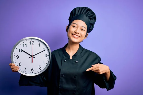 身穿炊具制服 头戴帽子 头戴大钟的中国女厨师满脸诧异地倒计时 — 图库照片