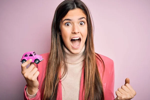 Menina Bonita Jovem Segurando Brinquedo Carro Pequeno Sobre Fundo Rosa — Fotografia de Stock