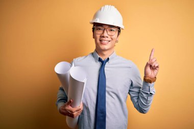 Güvenlik kaskı takan genç, yakışıklı mimar elinde planlarla bir fikre ya da soru işaretine şaşırdı.