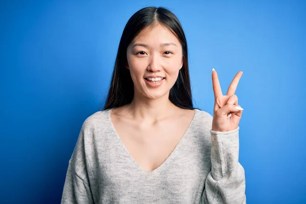 Junge Schöne Asiatische Frau Lässigem Pullover Steht Vor Blauem Hintergrund — Stockfoto