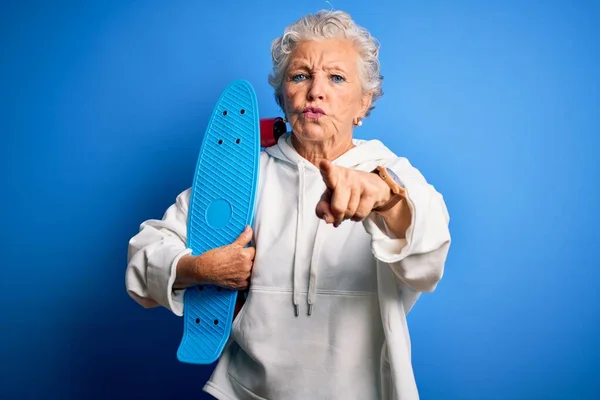 Senior Hermosa Mujer Deportiva Sosteniendo Patín Pie Sobre Fondo Azul — Foto de Stock