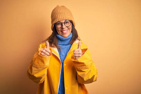 Middelbare Leeftijd Vrouw Dragen Gele Regenjas Winter Hoed Geïsoleerde Achtergrond — Stockfoto