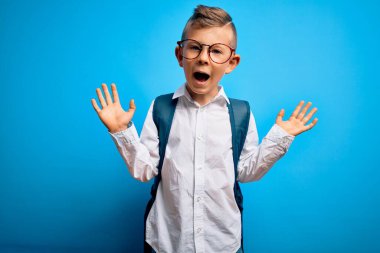 Mavi arka plan üzerinde akıllı gözlük ve okul çantası takan küçük beyaz çocuk çılgın ve başarıyı kollarını kaldırıp heyecanla haykırarak kutluyor. Kazanan konsept