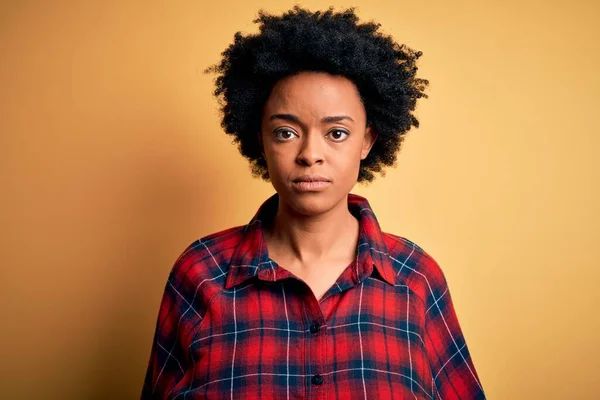 顔に真剣な表情でカジュアルなシャツを着て巻き毛を持つ若い美しいアフリカ系アメリカ人アフロ女性 シンプルで自然なカメラを見て — ストック写真