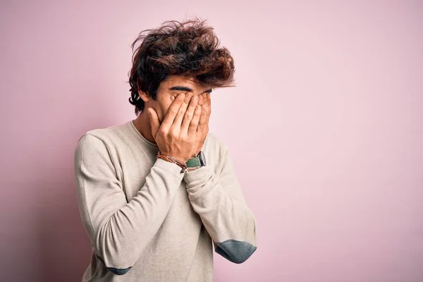 Young handsome man wearing casual t-shirt standing over isolated pink background rubbing eyes for fatigue and headache, sleepy and tired expression. Vision problem
