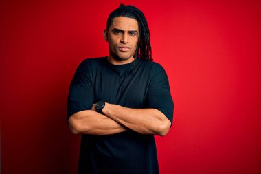 Rastgele tişört giyen, kuşkucu, gergin ve suratında çapraz kollu tasvip etmeyen Afro-Amerikan genç adam. Negatif kişi.