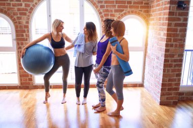 Mutlu gülümseyen genç ve güzel bir spor kadını grubu. Beden dersinden sonra yüzünde gülümsemeyle ayakta dikilip konuşmak.