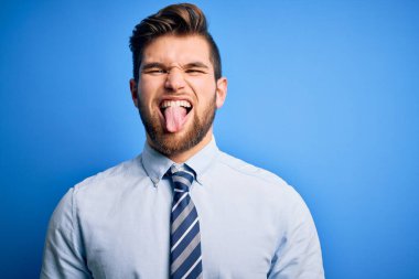 Sakallı, mavi gözlü, şık gömlekli ve kravatlı genç, sarışın iş adamı. Komik bir ifadeyle dilini dışarı çıkartıyor. Duygu kavramı.