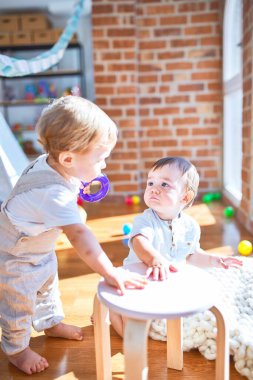 Anaokulunda bir sürü oyuncakla oynayan güzel çocuklar.