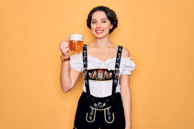 Mavi gözlü güzel Alman kadın geleneksel Ekim Festivali elbisesi giyiyor mutlu bir yüzle bira kavanozu içiyor ve gülümsüyor.