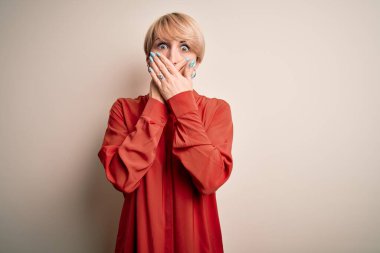 Genç, güzel iş kadını, kısa saçlı, izole edilmiş arka planda duran, ağzı yanlışlıkla ellerle kapatan sarışın kadın. Gizli konsept.