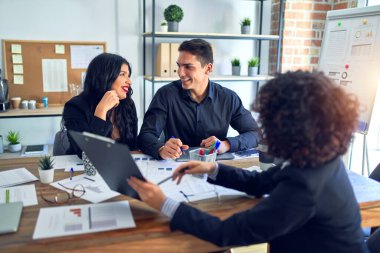 Group of business workers smiling happy and confident. Working together with smile on face reading documents and  speaking at the office