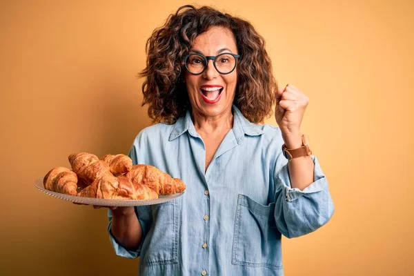 Middelbare Leeftijd Mooie Vrouw Met Bord Met Croissants Geïsoleerde Gele — Stockfoto