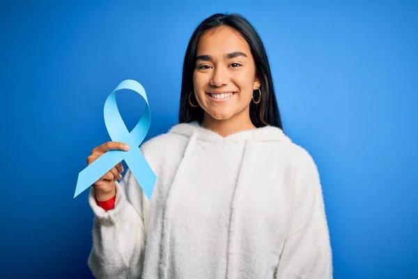 Młoda Azjatycka Kobieta Trzyma Niebieski Symbol Wstążki Raka Stojąc Odosobnionym — Zdjęcie stockowe