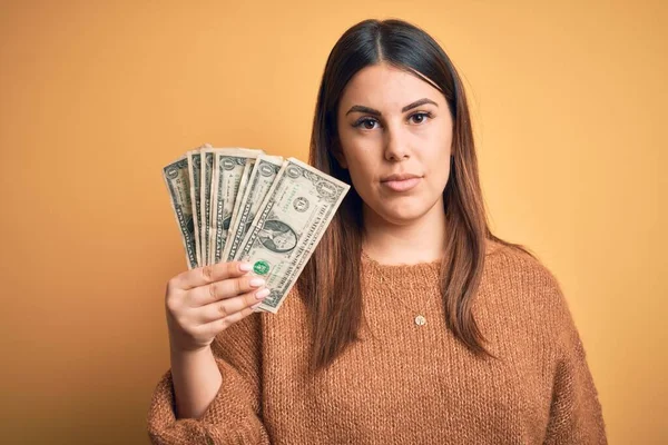 Joven Hermosa Mujer Sosteniendo Dólares Pie Sobre Fondo Naranja Aislado — Foto de Stock