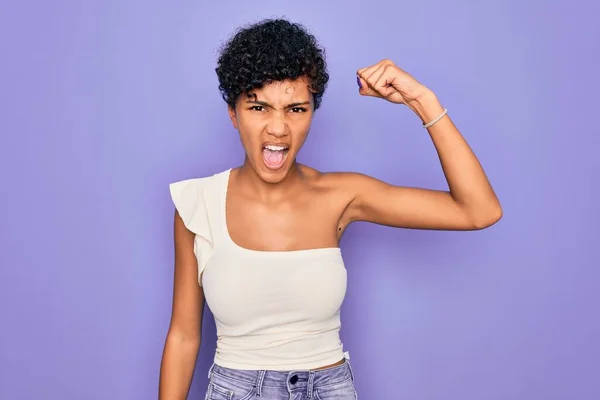紫の背景にカジュアルなTシャツを着た若い美しいアフリカ系アメリカ人アフロ女性は怒りながら叫びながら 怒りと怒りに苛立ちと怒りを上げ怒っています 激怒と積極的な概念 — ストック写真