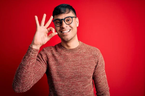 Mladý Pohledný Hispánec Šprtských Brýlích Nad Červeným Pozadím Usmívající Pozitivně — Stock fotografie