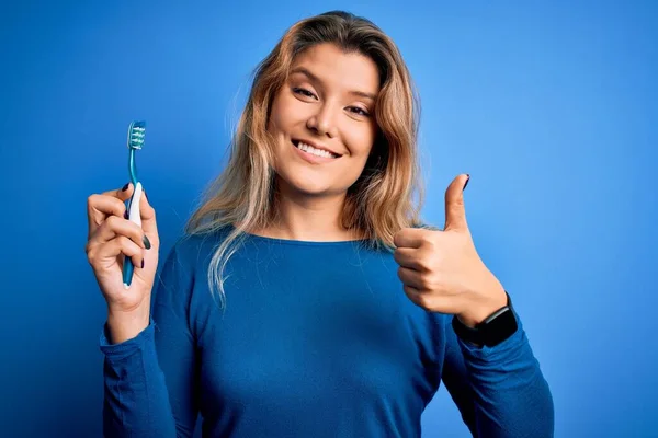 Jovem Mulher Loira Bonita Usando Escova Dentes Sobre Fundo Azul — Fotografia de Stock
