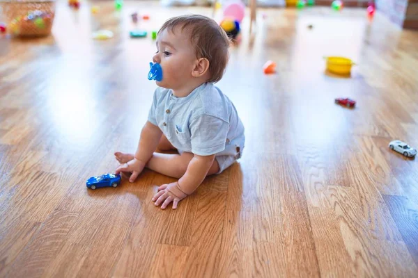 Adorável Criança Sentada Chão Usando Chupeta Brincando Torno Lotes Brinquedos — Fotografia de Stock