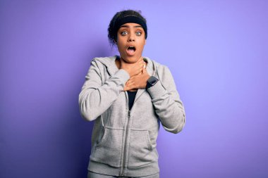 Genç Afrikalı Amerikalı sporcu kadın mor arka planda spor giyerek spor yapıyor ve boğularak ölüyor çünkü boğularak can yakıyor. Sağlık problemi. Boğulma ve intihar konsepti.