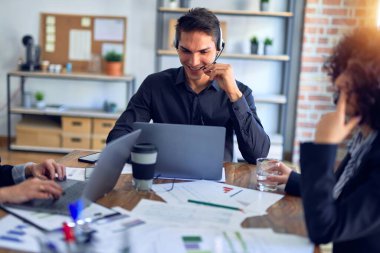 Group of call center workers smiling happy and confident. Working together with smile on face using headset at the office.