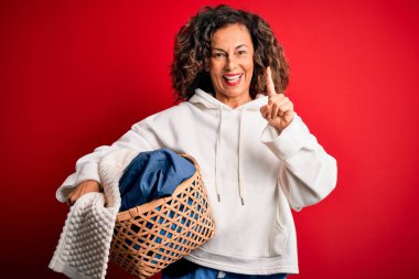 Orta yaşlı güzel bir kadın elinde sepet tutuyordu. Kırmızı arka planda giysileri vardı. Bir fikir ya da soru işareti ile şaşırmıştı.