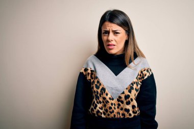 İzole edilmiş beyaz arka planda duran, kuşkucu ve gergin, sorun yüzünden somurtkan, gündelik eşofman giyen genç ve güzel bir kadın. Negatif kişi.