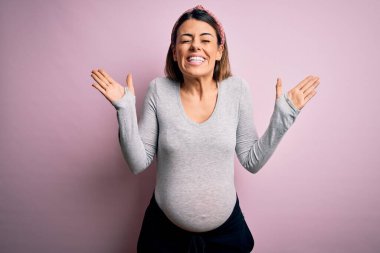 Genç, güzel, esmer bir kadın hamile, pembe arka planda bebek bekliyor. Başarılı olmak için deli ve çılgın bir kutlama yapıyorlar. Kollarını kaldırmış, gözleri kapalı, heyecanlı çığlıklar atıyorlar. Kazanan konsept