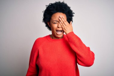 Kıvırcık saçlı, kırmızı kazaklı, Afro-Amerikan genç, güzel bir kadın. Yarı yüzünü, gözünü ve ağzını elleriyle kapatmaktan yorulmuş. Yüzüm acıyor..