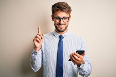 Genç işadamının beyaz arka plan üzerinde akıllı telefon kullanarak konuşması bir fikir veya soru işareti ile şaşırttı.