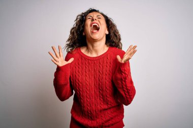 Orta yaşlı esmer kadın izole edilmiş beyaz arka planda dikilmiş başarıyı kutluyor kollarını kaldırmış, gözlerini kapatmış heyecanlı çığlıklar atıyor. Kazanan konsept