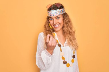 Genç, sarışın, mavi gözlü, güneş gözlüklü, aksesuar takan güzel bir hippi kadın.