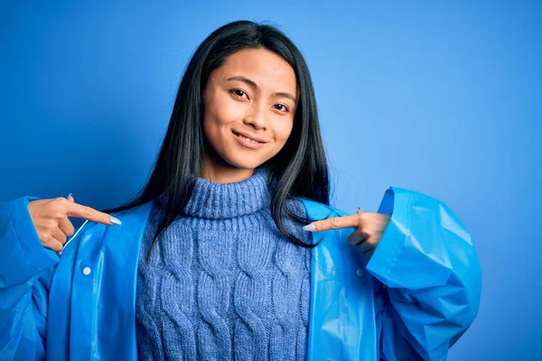 Jonge Mooie Chinese Vrouw Draagt Regenjas Staan Geïsoleerde Blauwe Achtergrond — Stockfoto