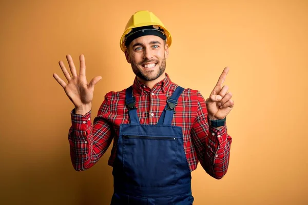 작업복을 헬멧을 건축가가 위에서 자신있고 행복하게 웃으면서 손가락으로 손가락을 — 스톡 사진