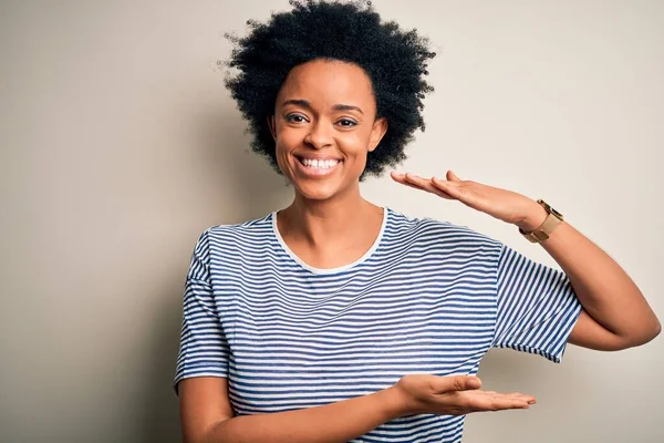 大きなと大規模なサインを示す手で縞模様のTシャツジェスチャーを着て巻き毛を持つ若い美しいアフリカ系アメリカ人アフロ女性は シンボルを測定します カメラを見て微笑んだ 概念の測定 — ストック写真