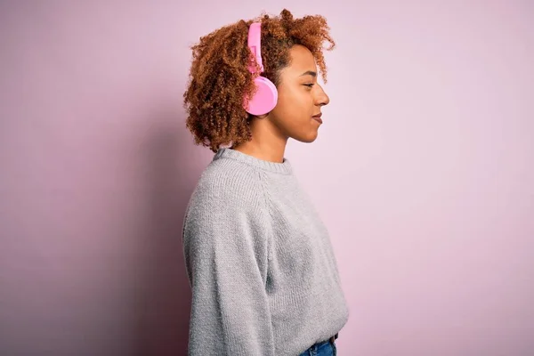머리가 곱슬곱슬 아프리카 미국인젊은 분홍색 헤드폰을 음악을 — 스톡 사진
