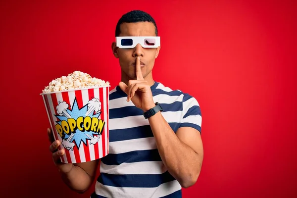 年轻英俊的非洲裔美国男人用3D眼镜看电影 吃爆米花 要求保持安静 手指放在嘴唇上 沉默和秘密概念 — 图库照片