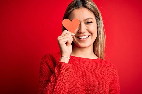Genç Güzel Bir Kadın Elinde Kalp Kartıyla Kırmızı Arka Planda — Stok fotoğraf